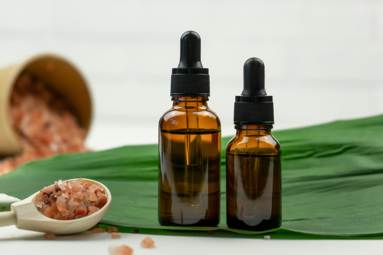 Dropper bottles of serum or essential oil and sea salt standing